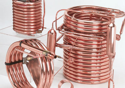 Three different copper coils standing together constructed by Spinco Metal Products Inc in Newark, NY